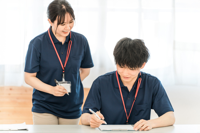 介護士の男女が書類に記入