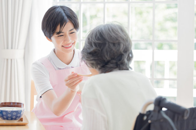 介護者が高齢女性に食事を介助