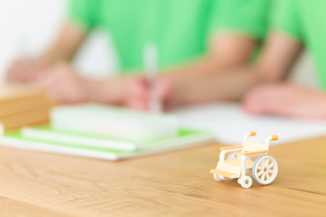 勉強する学生と車椅子のミニチュア