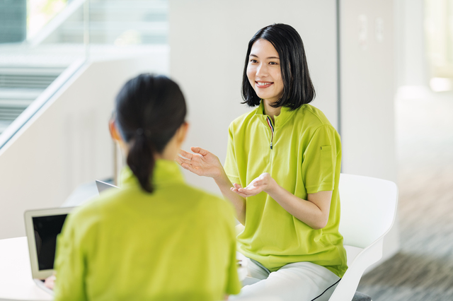 明るい屋内で女性2人が会話する様子